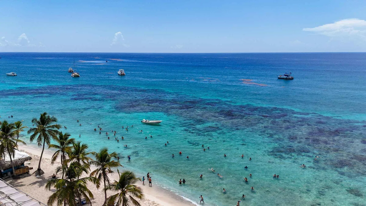 Catamaran passengers on the white sand beach of Isla Catalina on an all-inclusive Catalina Island snorkeling day trip from Punta Cana